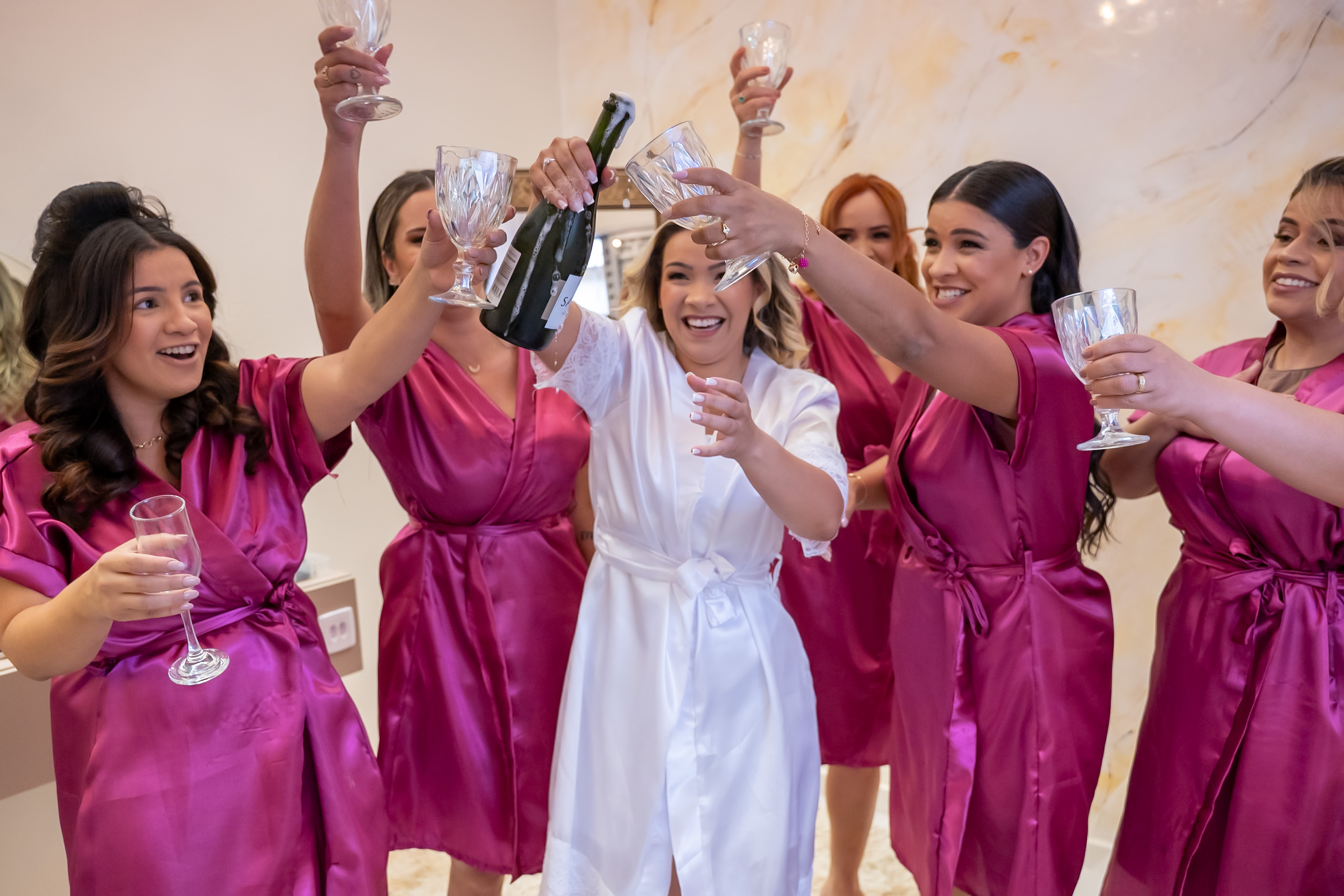Noiva celebrando com as madrinhas durante a preparação