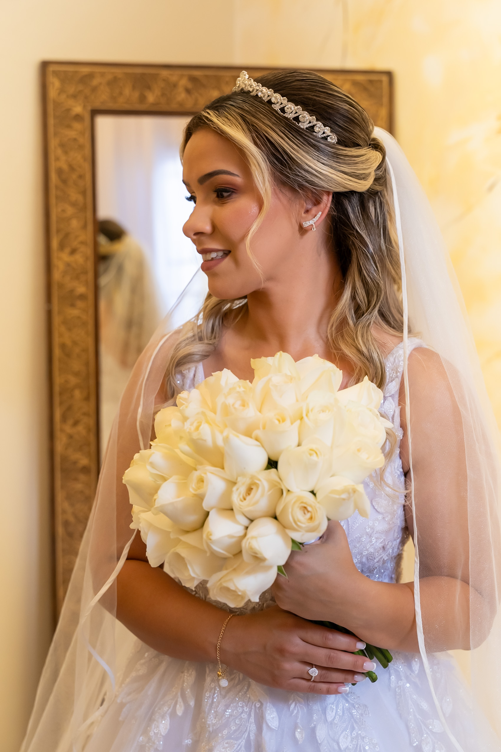 Noiva pronta segurando um buquê de rosas brancas